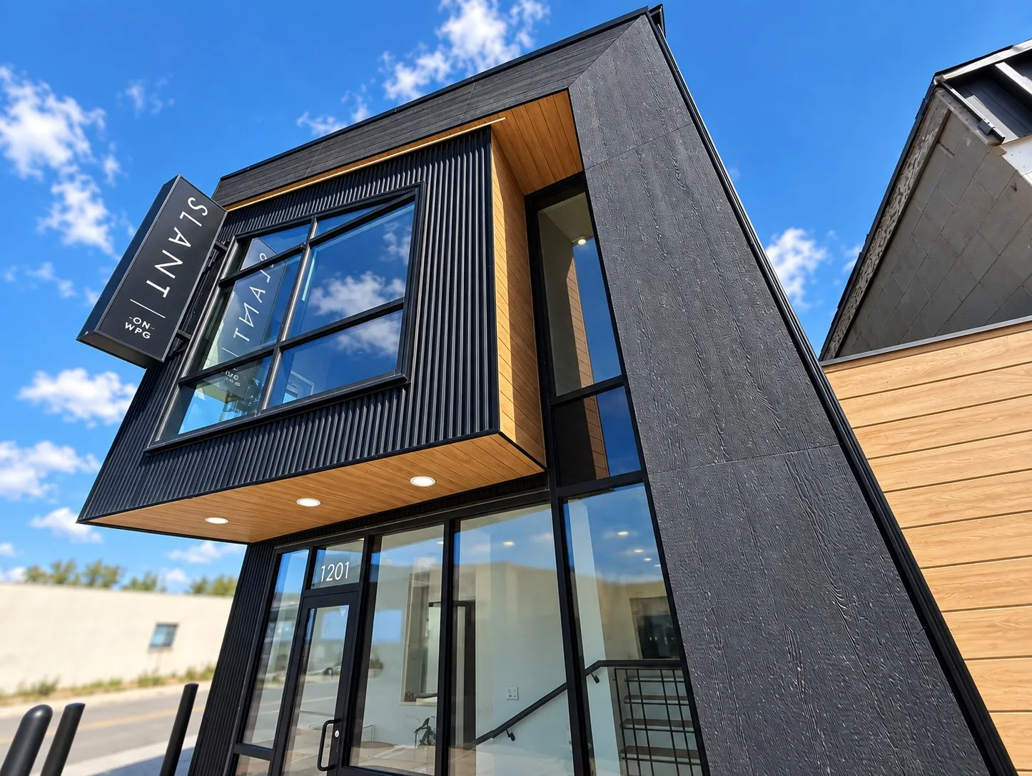 SLANT today from the street, the black two-storey building with its wood soffit and tall corner windows